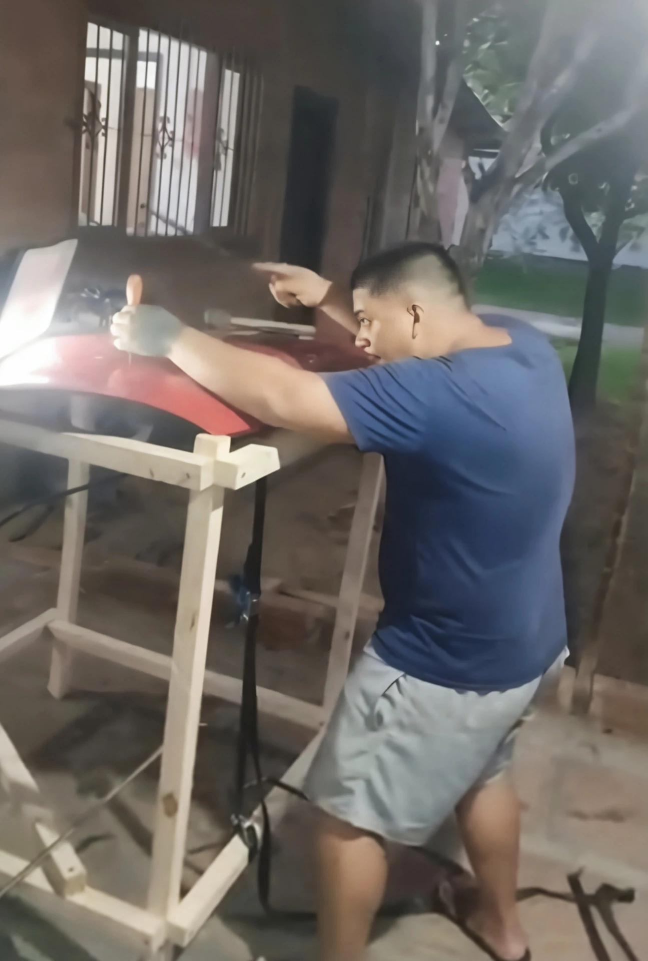 Aluno treinando reparo em capô vermelho com luz de leitura