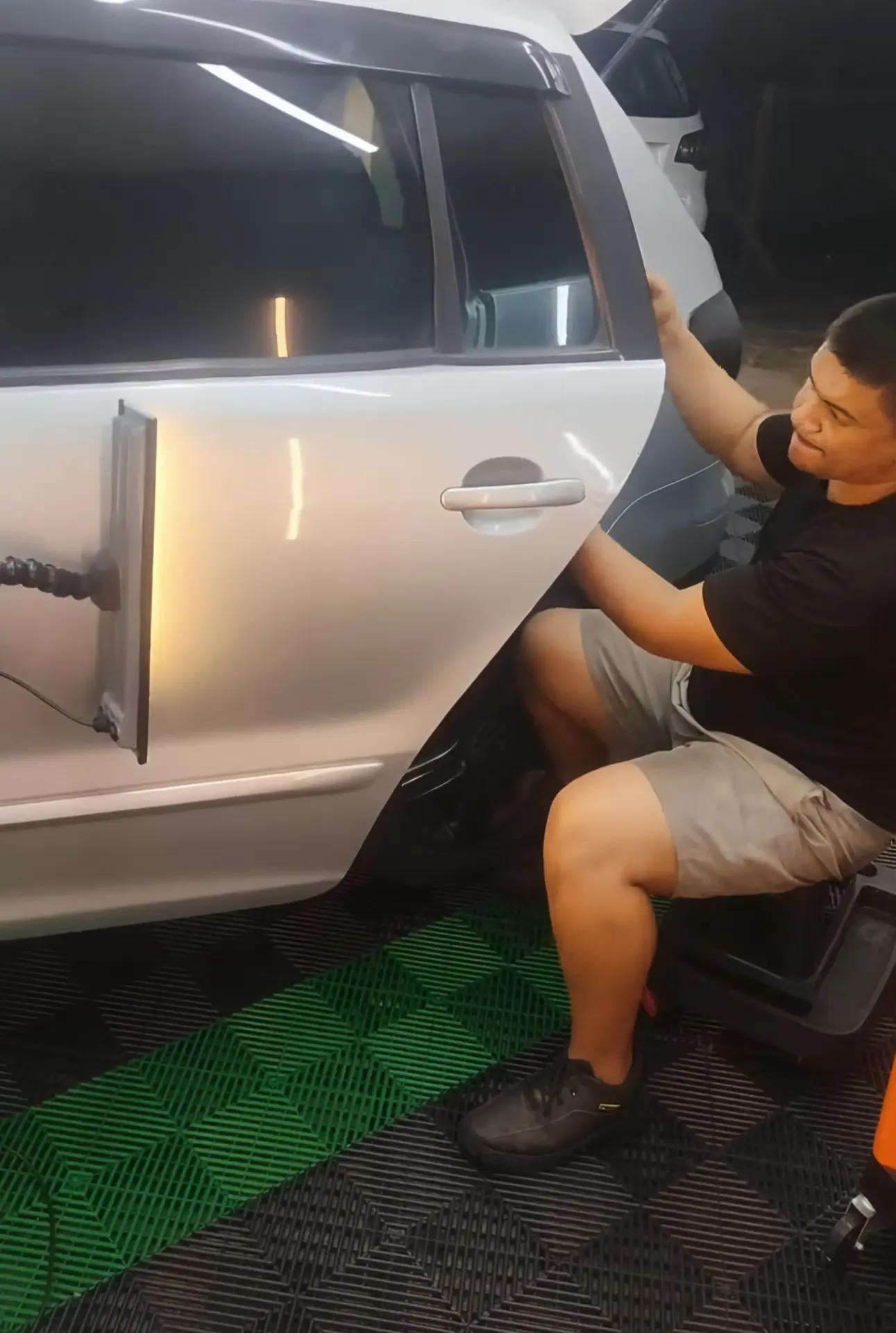 Aluno em aula praticando martelinho de ouro em porta de carro